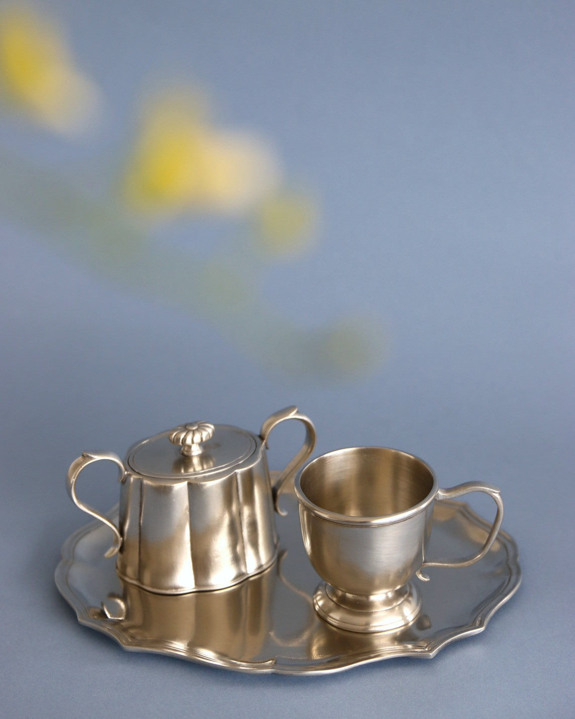 ピューターに、そっと映り込む新しい季節の花々。