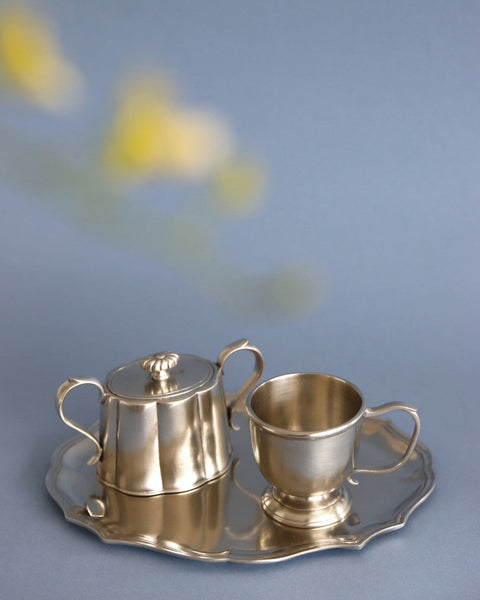 ピューターに、そっと映り込む新しい季節の花々。